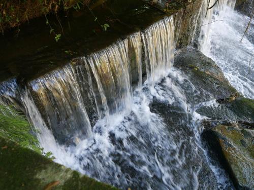 a waterfall on the side of a river at Pousada da Alcobaça in Itaipava