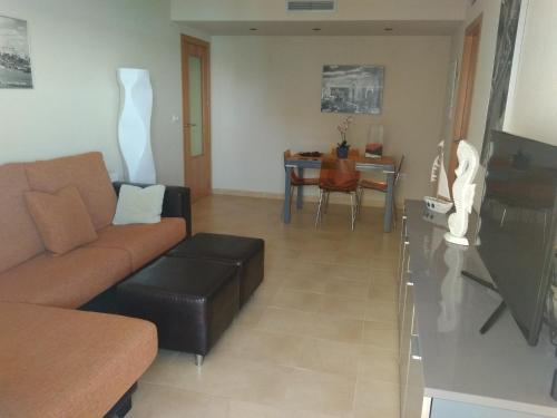sala de estar con sofá y mesa en CORMORANT SUITE, sea terrace & pools, en La Manga del Mar Menor