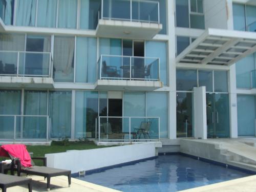 a building with a swimming pool in front of a building at Apartamento en BalaBeach María Chiquita in front of the beach 2hab in Colón