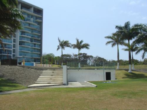 a building with stairs and palm trees in a park at Apartamento en BalaBeach María Chiquita in front of the beach 2hab in Colón