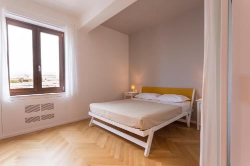 a white bedroom with a bed and a window at Residence Itaca in Castellammare del Golfo