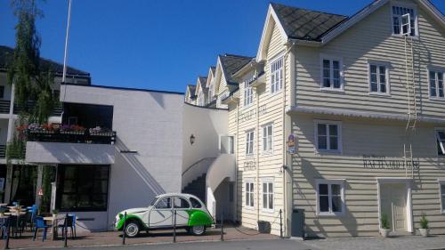 an old green car parked in front of a building at Havila Hotel Raftevold in Hornindal