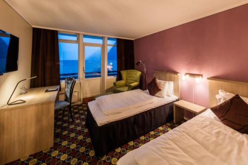 um quarto de hotel com duas camas e uma televisão em Havila Hotel Raftevold em Hornindal