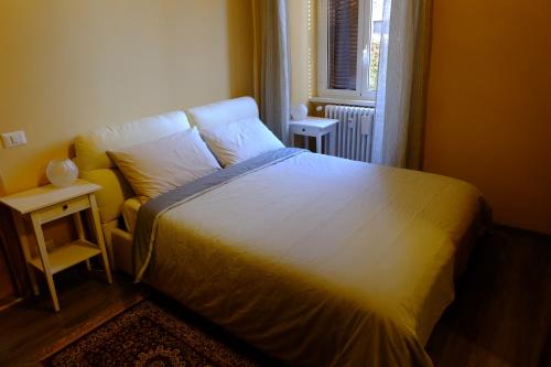 a bedroom with a bed with a white bedspread and a window at Villa Ella in Rome