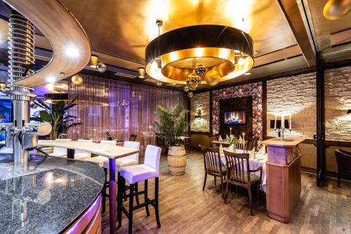 a restaurant with tables and chairs and a chandelier at Akzent Hotel Tietmeyer & Cross Side in Schöppingen