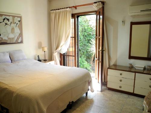 1 dormitorio con 1 cama y puerta corredera de cristal en Casa de alquiler San Juan en San Juan