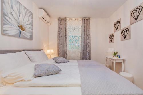 - une chambre avec un lit blanc et une fenêtre dans l'établissement Villa Sweet Home, à Mokošica