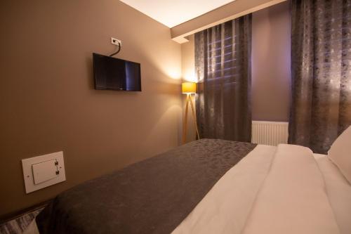 1 dormitorio con 1 cama y TV en la pared en Staron Otel en Zonguldak