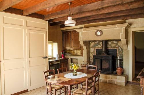 a kitchen with a table and a fireplace at Countryhouse La Rose in Les Thons