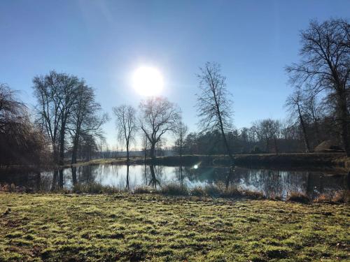 a view of a lake with the sun in the sky at König`s Hotel am Schlosspark in Rheda-Wiedenbrück