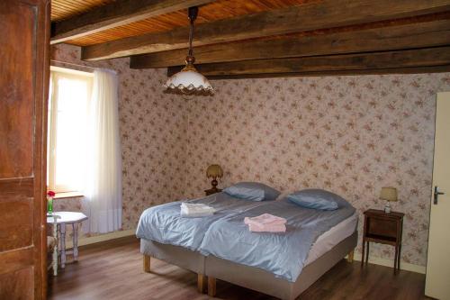 a bedroom with a bed with blue pillows on it at Countryhouse La Rose in Les Thons