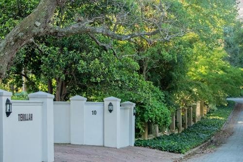a white fence in front of a tree at Tehillah Guest House in George