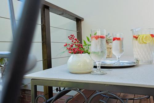 a table with three wine glasses and a vase with flowers at Tehillah Guest House in George