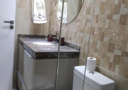 y baño con lavabo, aseo y espejo. en moradia garden village, en Balneário Camboriú