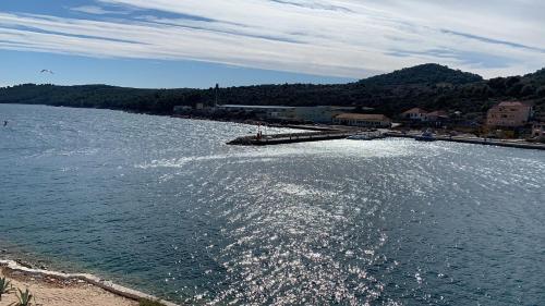a large body of water with a pier and buildings at Apartmani Sali Seaview in Sali