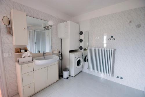 a white bathroom with a sink and a washing machine at B&B Tra gli ulivi in Rocca San Giovanni