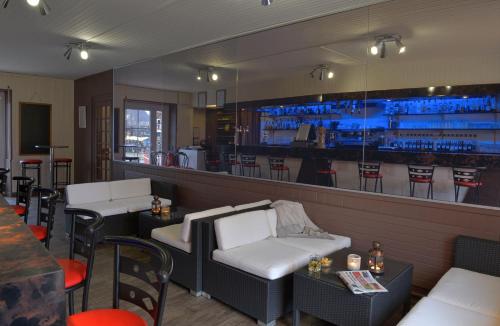 a restaurant with a bar with white chairs and tables at LA PROMENADE in Coings