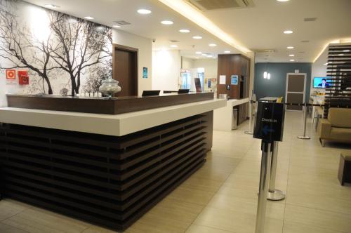 a lobby of a store with a counter in the middle at Golden Tower Aeroporto - Lizz - by Fênix Hotéis in Uberlândia