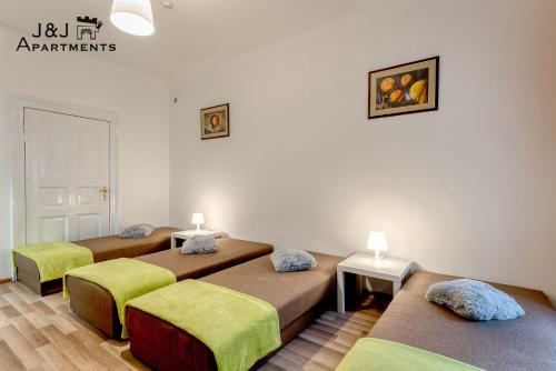 托伦J&J Apartments Łazienna 30 - 10的带三张床和两张桌子的房间