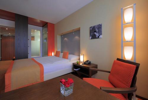 a hotel room with a bed and a table and a chair at Radisson Blu Hotel, St. Gallen in St. Gallen