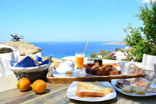 een ontbijttafel met eten en uitzicht op de oceaan bij Vega Apartments in Tinos Town