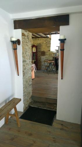 a hallway with a wooden floor and a wooden bench at La Ferme Blanche in MÃ©nil-Vin