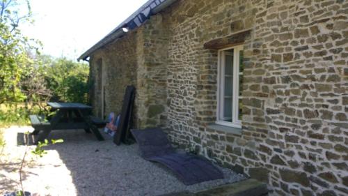 a brick building with a picnic table next to a window at La Ferme Blanche in MÃ©nil-Vin