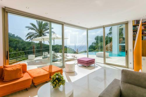 a living room filled with furniture and a large window at Villa Vadella by Eivillas in Cala Vadella