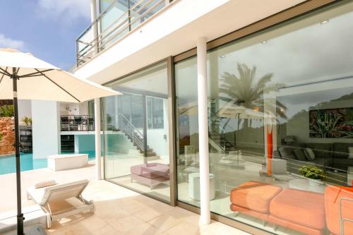 a glass extension of a house with a patio at Villa Vadella by Eivillas in Cala Vadella