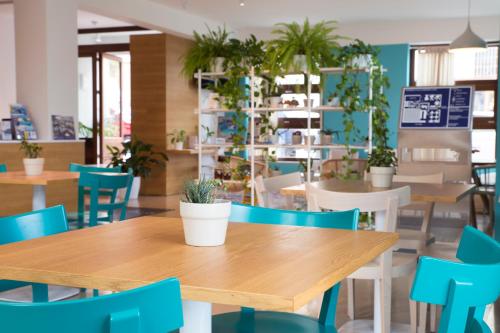 una sala da pranzo con tavoli, sedie e piante di Residence Itaca a Castellammare del Golfo