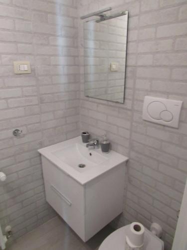 a white bathroom with a sink and a toilet at PIANETA ROMA 39 in Rome
