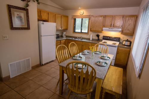 a kitchen with a table and chairs and a white refrigerator at Lewis & Clark Resort in Yankton