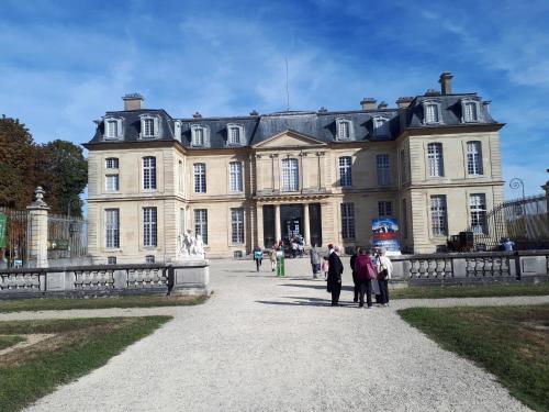 a group of people standing in front of a large building at Residence le Château in Champs-Sur-Marne