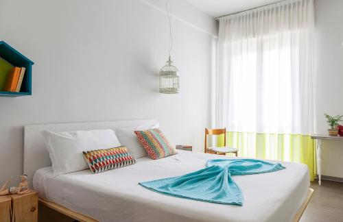 una camera da letto con un letto con una coperta blu sopra di Hotel Madison a Rimini