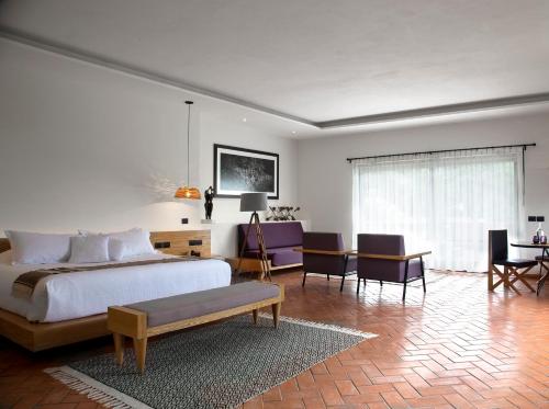 - une chambre avec un lit, une table et des chaises dans l'établissement Hotel Boutique Casa Fernanda, à Tepoztlán