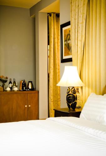 a bedroom with a bed and a table with a lamp at Phukumhom Khao Yai in Wangkata