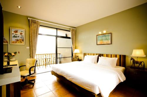 a bedroom with a large white bed and a window at Phukumhom Khao Yai in Wangkata