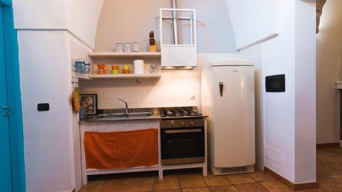 a small kitchen with a stove and a refrigerator at La Casetta in Calimera
