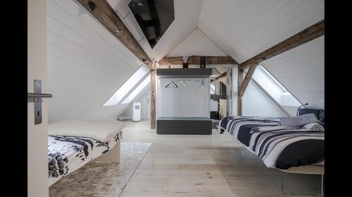 two beds in a attic bedroom with skylights at Luxury Penthouse Apartment in Zürich