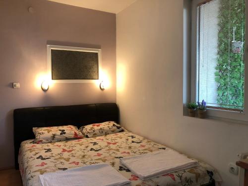 a small bedroom with a bed and a window at Square Vanilla Apartments in Skopje