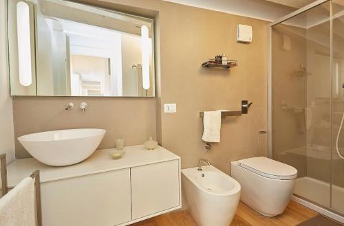 uma casa de banho com um lavatório, um WC e um espelho. em La Martorana, Luxury apartment with terrace em Palermo