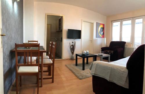 a living room with a bed and a table and chairs at Square Vanilla Apartments in Skopje