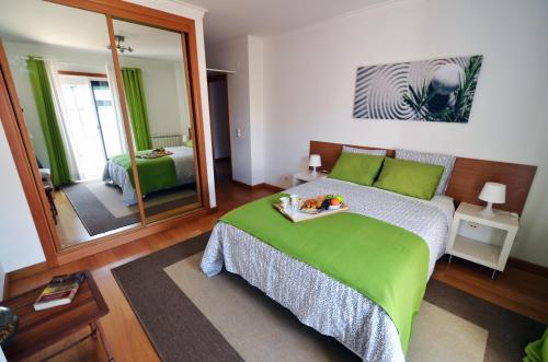 een slaapkamer met een groen bed en een spiegel bij Expo Marina Lis in Lissabon