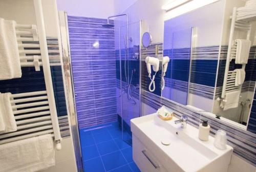 a bathroom with a sink and a shower with blue tiles at Casa Teresa Bed & Breakfast in Naples