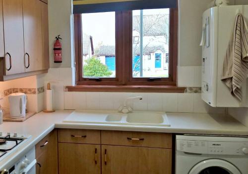 kuchnia ze zlewem i oknem w obiekcie Home from Holm w mieście Inverness