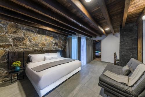 - une chambre avec un grand lit et un mur en pierre dans l'établissement Matian Hotel Boutique, à Tequisquiapan