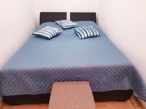 a bed with two pillows on it in a room at Apartment Near the Lakes in Plitvička Jezera