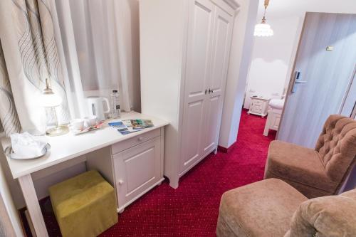 a room with a desk and a chair and red carpet at Hotel Casa David in Craiova