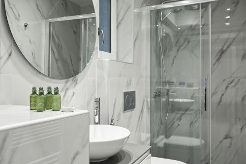 a bathroom with a shower and a sink and a mirror at Valaoritou Boutique Apartment,Kolonaki in Athens