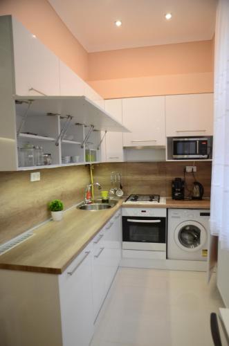una cocina con armarios blancos y fregadero en Green Island in the downtown with free parking en Debrecen